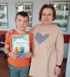 Dziecko pozuje do zdjęcia z instruktorką i dyplomem